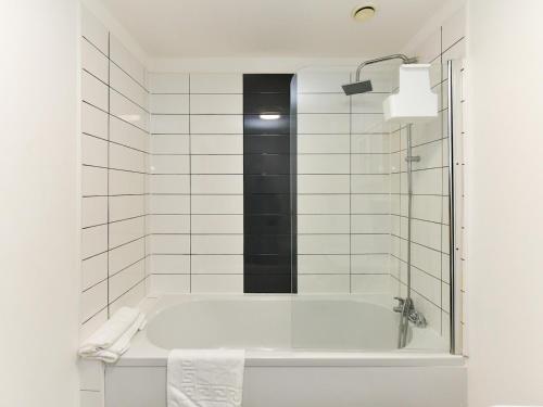 卡地夫的住宿－Pass the Keys Sleeps 5 close to Bay City，白色的浴室设有浴缸和淋浴。