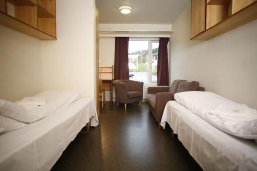 una camera ospedaliera con due letti e una sedia di Førde Sommarhotell a Førde
