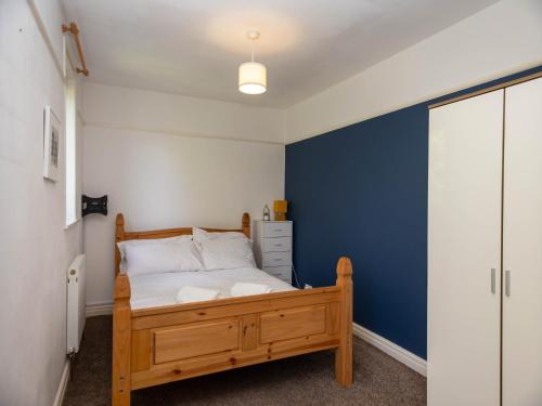 a bedroom with a bed with a blue accent wall at Pass the Keys 10 mins to City Centre Sleeps 6 in Manchester