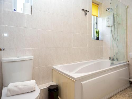 a bathroom with a tub and a toilet and a sink at Pass the Keys 10 mins to City Centre Sleeps 6 in Manchester