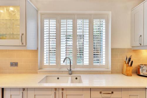 uma cozinha com um lavatório e uma janela em Pass the Keys Large family home in picturesque village em Westerham