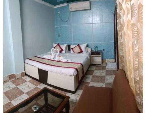 een slaapkamer met een bed en een tafel in een kamer bij EMBLIC HOTEL & RESTAURANT, Bolpur in Bolpur