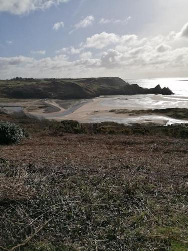 a view of a beach with the ocean in the background at 1 Bed cottage The Stable at Llanrhidian Gower with sofa bed for additional guests in Swansea