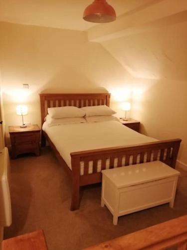a bedroom with a large bed with two night stands at 1 Bed cottage The Stable at Llanrhidian Gower with sofa bed for additional guests in Swansea
