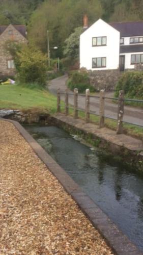 a small stream of water with a house in the background at 1 Bed cottage The Stable at Llanrhidian Gower with sofa bed for additional guests in Swansea