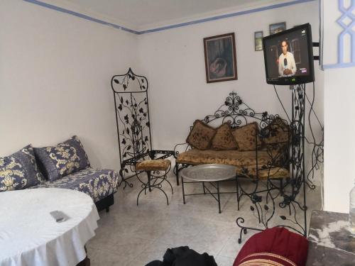 a living room with a couch and a tv at Maison ghita in Asilah