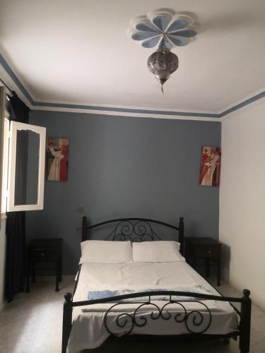 a bedroom with a bed with a ceiling fan at Maison ghita in Asilah