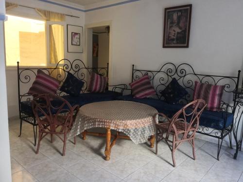 a living room with a couch and a table and chairs at Maison ghita in Asilah