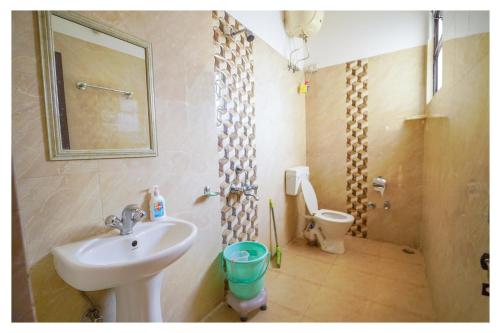 a bathroom with a sink and a toilet at Shivalik River Retreat in Almora