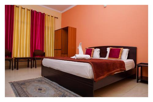 a bedroom with a large bed with red walls at Shivalik River Retreat in Almora