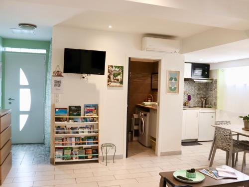 uma cozinha e sala de estar com televisão na parede em Appartement en rez-de-villa avec jardin em Hyères