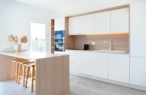 a kitchen with white cabinets and a white counter top at Portomar Apartments in Portocolom