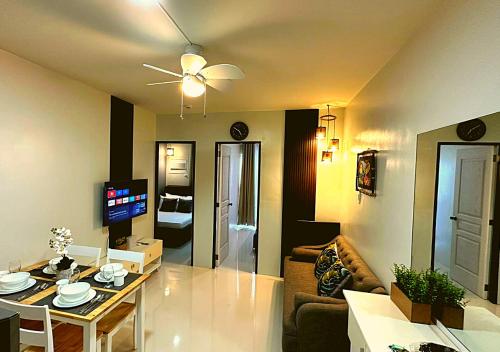 a living room with a couch and a table with a television at Affordable and Elegant 2BR Apartment with a Balcony plus FREE Swimming Pool and Gym-5Kunzite in Puerto Princesa City