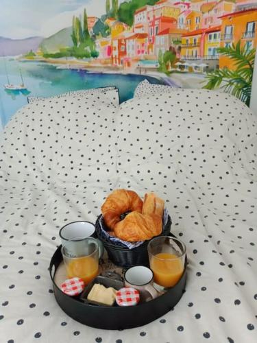 - un plateau de nourriture avec des viennoiseries et du jus d'orange sur un lit dans l'établissement Logements mitoyens 