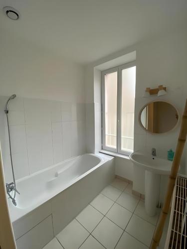 une salle de bain blanche avec une baignoire et un lavabo dans l'établissement Appartement cosy à Vals, à Vals-les-Bains