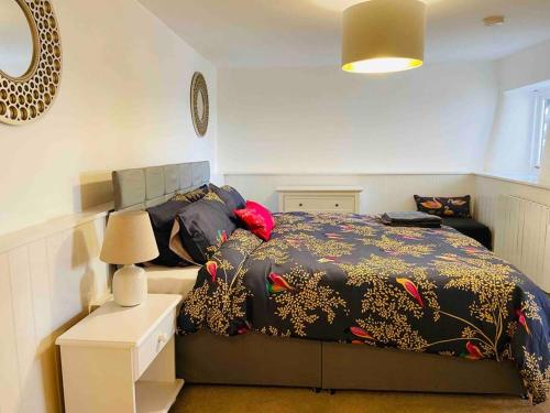 a bedroom with a bed with a black comforter at The Mill Stylish Rural Apartment with Beautiful Views in Welsh Newton Common