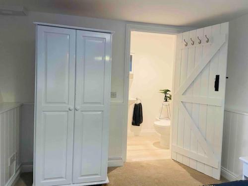 a white closet with a sliding door in a bathroom at The Mill Stylish Rural Apartment with Beautiful Views in Welsh Newton Common