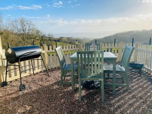 a grill and two chairs and a table with a grill and a bbq at The Mill Stylish Rural Apartment with Beautiful Views in Welsh Newton Common