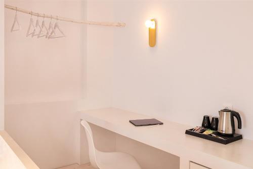 a white desk with a candle on top of it at Potokaki Beachfront Hotel in Pythagoreio