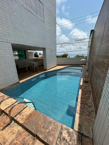 a swimming pool in the side of a building at PONTA NEeGRA FLAT - HOTEL MILOR in Natal