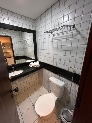 a bathroom with a toilet and a sink and a mirror at Flat Praia de PontaNegra - Natal RN in Natal