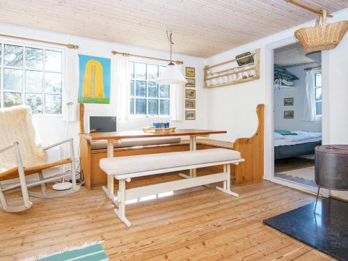 a living room with a wooden table and a bench at 4 person holiday home in Ulfborg in Fjand Gårde