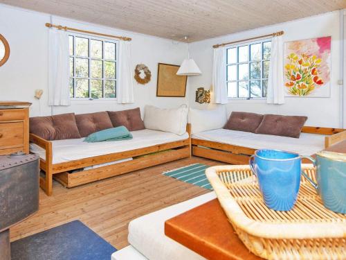 a living room with a couch and two windows at 4 person holiday home in Ulfborg in Fjand Gårde