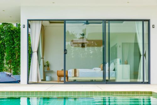 a room with a bed and a pool at 5House:A luxury beachfront villa on Samui 滨海5卧室别墅 in Hua Thanon Beach