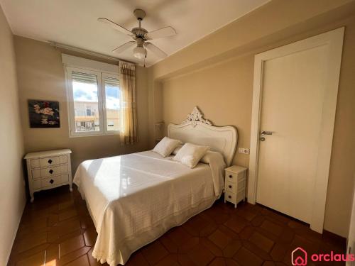 a bedroom with a white bed and a window at El Capricho in Benicàssim