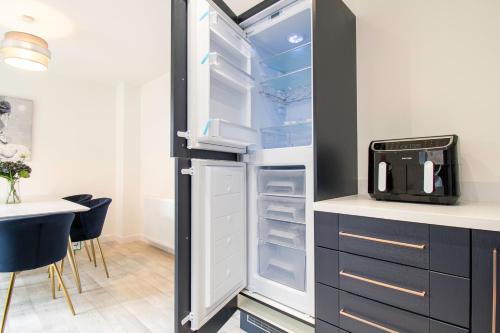 a refrigerator with its door open in a kitchen at Pass the Keys Beautiful Glasgow South Home in Glasgow