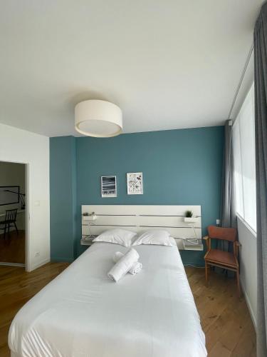 - une chambre avec un grand lit blanc et un mur bleu dans l'établissement Le Bonrepos - T3 sur les Ramblas de Toulouse, à Toulouse