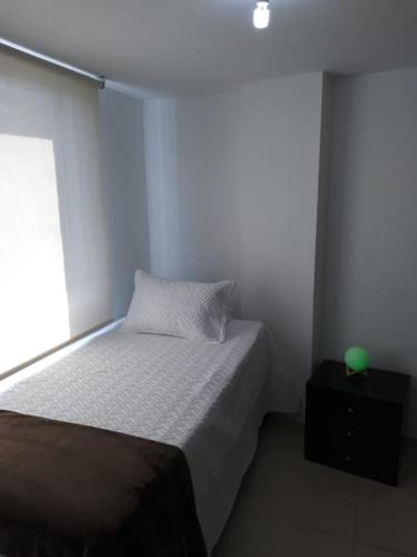 ein kleines Schlafzimmer mit einem Bett und einem Fenster in der Unterkunft MALAGA in Sabaneta