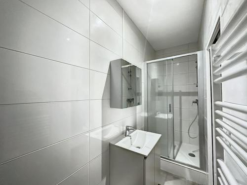 une salle de bain blanche avec un lavabo et une douche dans l'établissement Cosy appt cœur de Lyon Du Bœuf 2, à Lyon