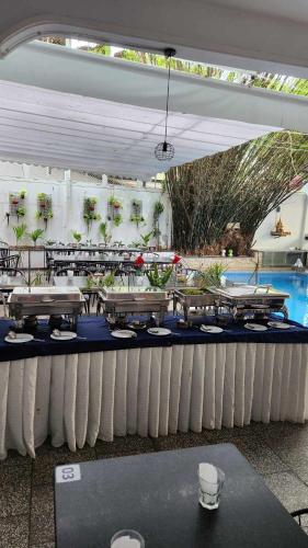 a group of tables in a pavilion with a pool at Bamboo9 Boutique in Phnom Penh