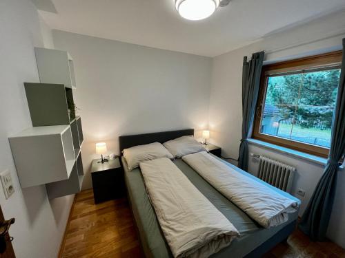 a bedroom with a bed with a window and two lamps at Draublick Sillian in Sillian