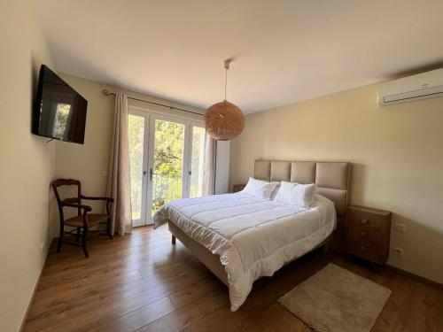 ein Schlafzimmer mit einem Bett und einem TV in der Unterkunft Bergerie de l'Horte in Tourouzelle