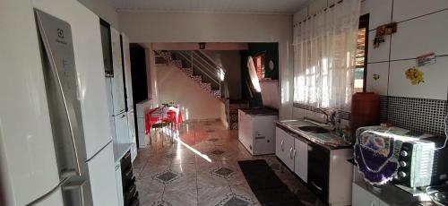 uma cozinha com um lavatório e uma escada num quarto em Sitio recanto Feliz em Mariana