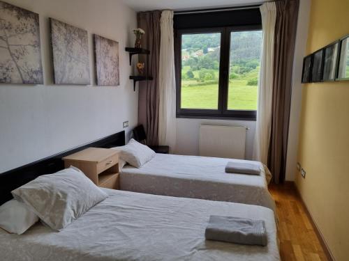 2 camas en una habitación con ventana en Piso zona hospital 7 personas en Oviedo