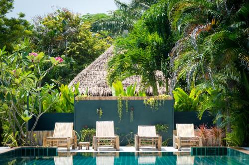 a group of chairs next to a swimming pool at Oasis Yoga Bungalows in Ko Lanta