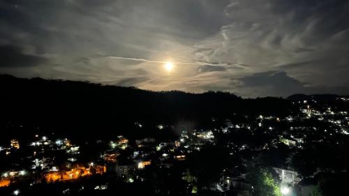 a view of a city at night with the moon at Rusty Bunk Villa in Kandy