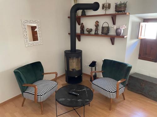 a living room with two chairs and a wood stove at Casa Vell de Valldemossa in Valldemossa