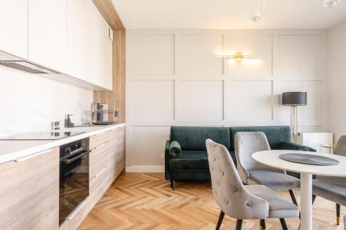 een keuken met een tafel en een groene bank bij RentPlanet - Apartamenty Księcia Witolda in Wrocław