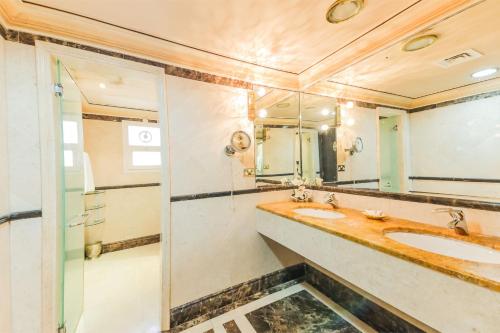 a bathroom with two sinks and a mirror at OYO 154 Bait AL Marmar Hotel in Sohar