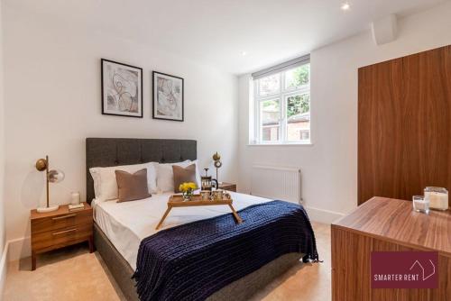 a bedroom with a bed with a table on it at Dorking - Brand New 1 Bedroom Apartment in Dorking