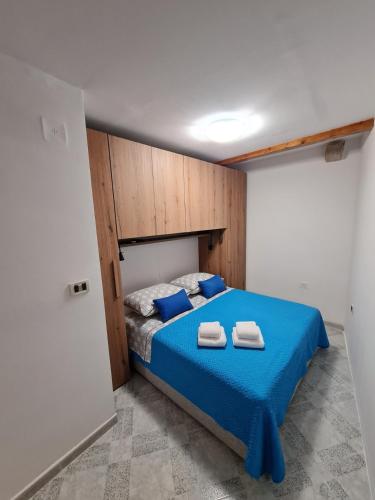 a bedroom with a blue bed with two towels on it at Studio Arsenale 7 in Rovinj