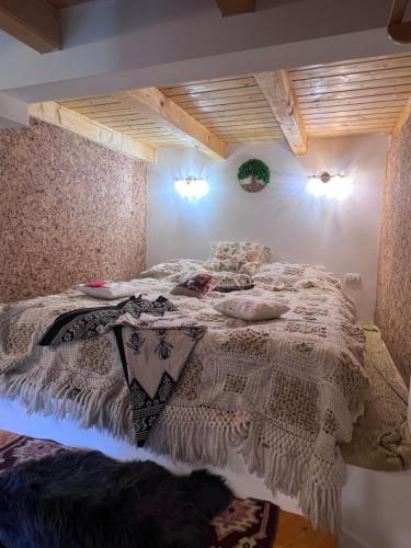 a bedroom with a bed with a white comforter at Casa Armonia in Bran
