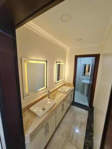 La salle de bains est pourvue de 2 lavabos et d'un grand miroir. dans l'établissement شقه ثلاث غرف ماستر فاخرة من غير سماسرة, au Caire