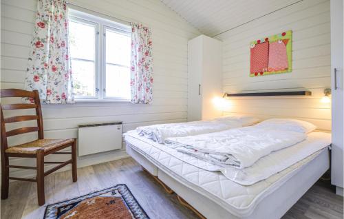 エーベルトフトにあるLovely Home In Ebeltoft With Private Swimming Pool, Can Be Inside Or Outsideのベッドルーム1室(ベッド1台、椅子、窓付)