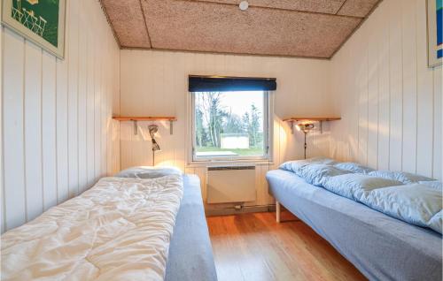 two beds in a room with a window at Awesome Home In Ebeltoft With Private Swimming Pool, Can Be Inside Or Outside in Ebeltoft