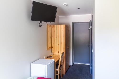 a room with a desk and a tv on a wall at Kuremaa Külalistemaja in Kuremaa